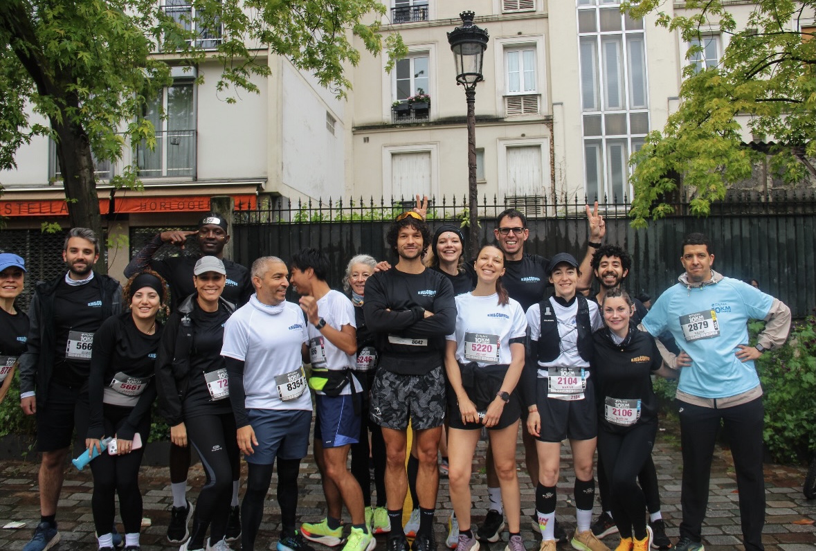 Groupe de coureurs souriants réunis avant le départ d'une course en ville